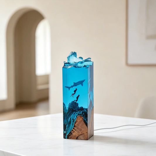 Handmade resin lamp with a whale shark swimming above two scuba divers in ocean-blue epoxy