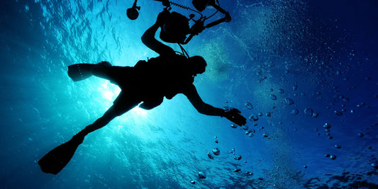 Scuba diver filming in the blue ocean