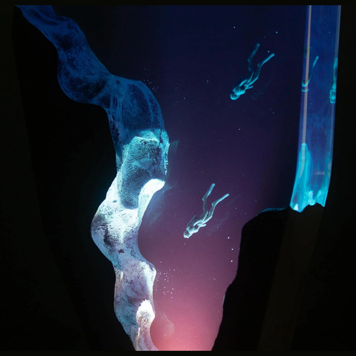 Double Dive resin lamp glowing in the dark, divers sinking into a blue abyss – Woodiny