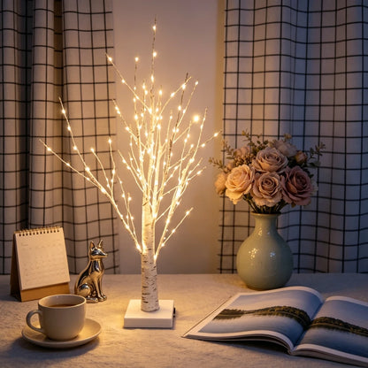 Birch tree lamp on a desk with flowers and books