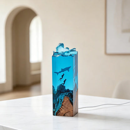 Handmade resin lamp with a whale shark swimming above two scuba divers in ocean-blue epoxy